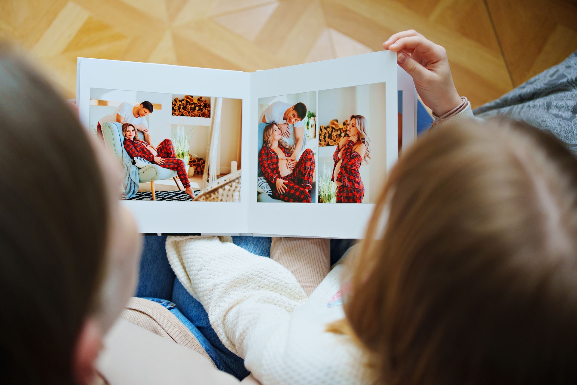 mother and daughter flips through a book with photos of dad and pregnant mom.